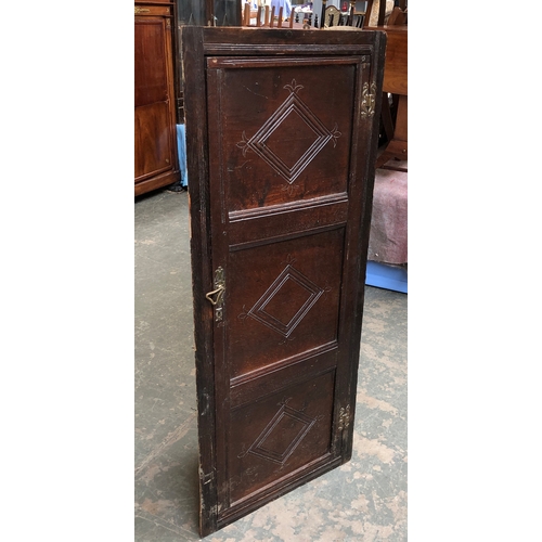 761 - An oak corner cupboard, formed from the front of a three panel coffer, 56x131cm