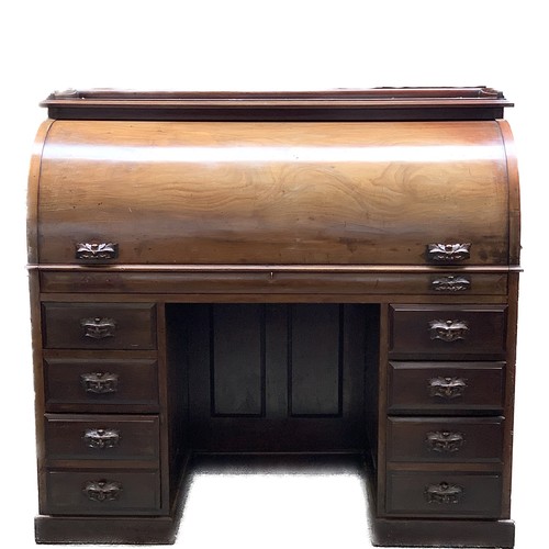 789A - A late 19th century roll top writing desk, the top with a three quarter moulded gallery, the rolltop... 