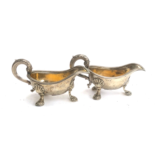 72 - A pair of white metal sauce boats, each with leaf capped handle, raised on three feet, approx. 16cmL