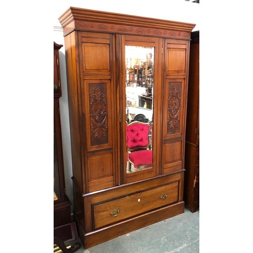 843 - An Edwardian mahogany wardrobe, central mirrored door flanked by carved panels and draw below, 119x4... 