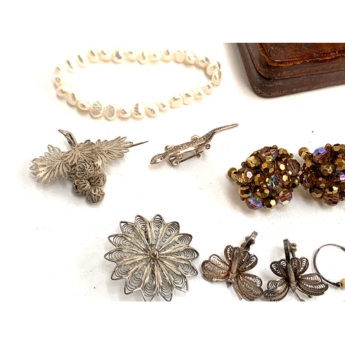 23 - A mixed lot of jewellery to include silver and marcasite bow brooch; white metal filigree butterfly ... 