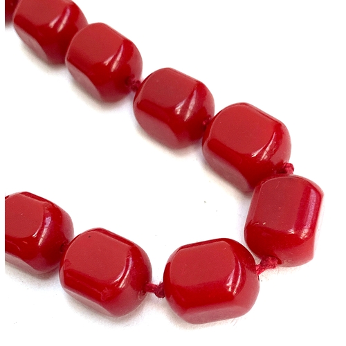 27 - A long string of cherry amber red bakelite type beads, the 54 beads each approx 1.6cm long, 130g