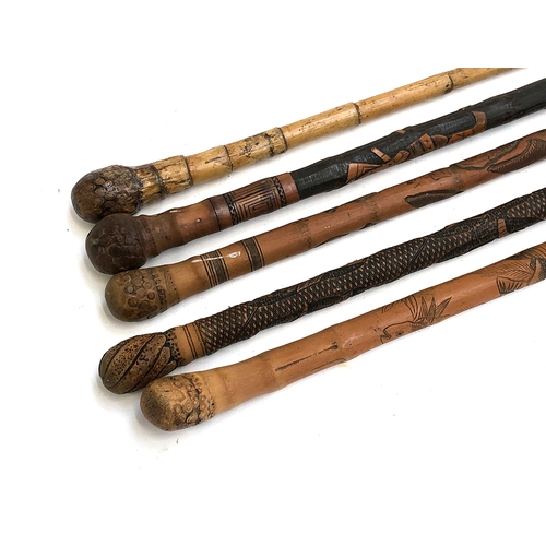 71 - A lot of five Japanese carved walking canes, some bamboo, carved with samurai, goldfish etc (5)