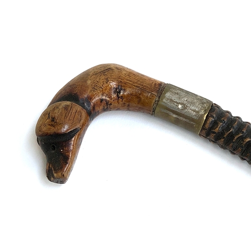 87 - Folk art interest: a naively carved walking stick with dog mask handle, 83cmL