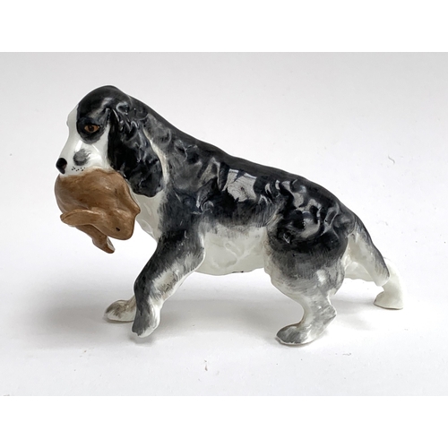 127 - A Royal Worcester porcelain figure of a spaniel holding a rabbit, model number 3310, 9cmH