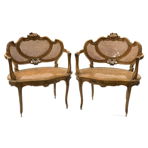 515 - A pair of bergere settles, 20th century, the carved rail with tripartite caned back, over a kidney s... 