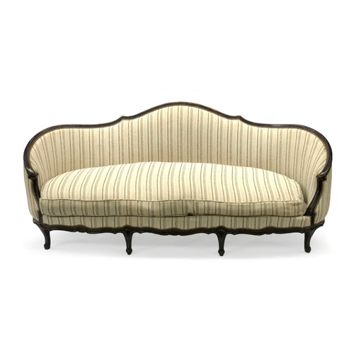 523 - A Moissonnier d'Aurevilly three seater sofa, with a carved ebonised beech frame, in a striped print,... 