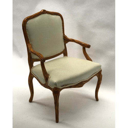 1642 - An Italian open arm chair, with matching footstool, the frames carved in naturalistic form, the chai... 