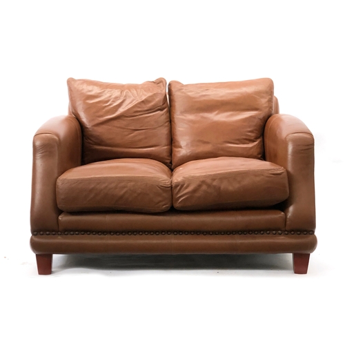 1667 - A modern brown leather two seater sofa, approx. 130cm wide