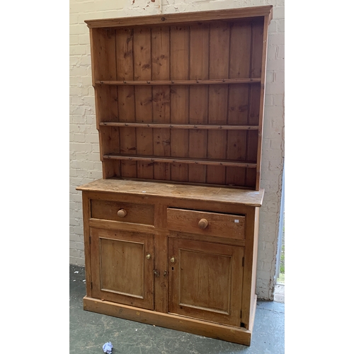 1693 - A small Victorian pine dresser, the top with three shelves, over a base of two drawers and two cupbo... 