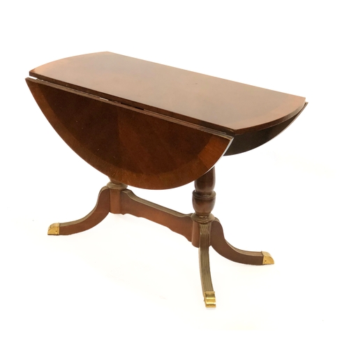 1711 - A mahogany veneer and crossbanded circular drop leaf dining table, 20th century, raised on twin balu... 