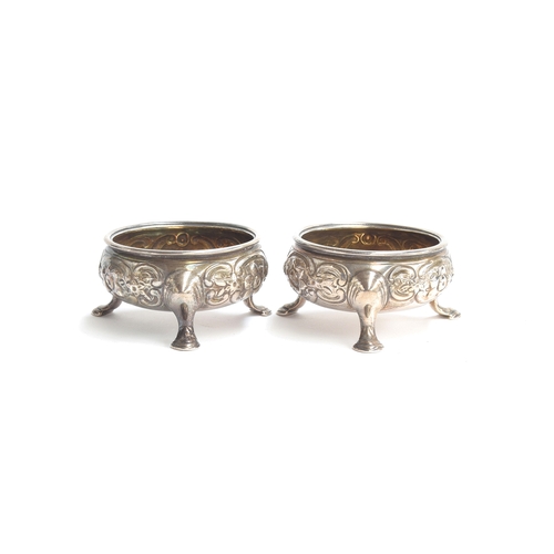 133 - A pair of George III silver salts, marks rubbed, with silver gilt interiors, later chased with folia... 