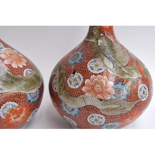 149 - A pair of large Japanese Kutani bottle bottle vases and covers (af), dragon on an orange and white g... 