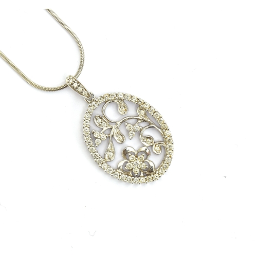 83 - A 14ct white gold and diamond floral pendant of pierced form, 2.2cm long, on a 14ct white gold snake... 