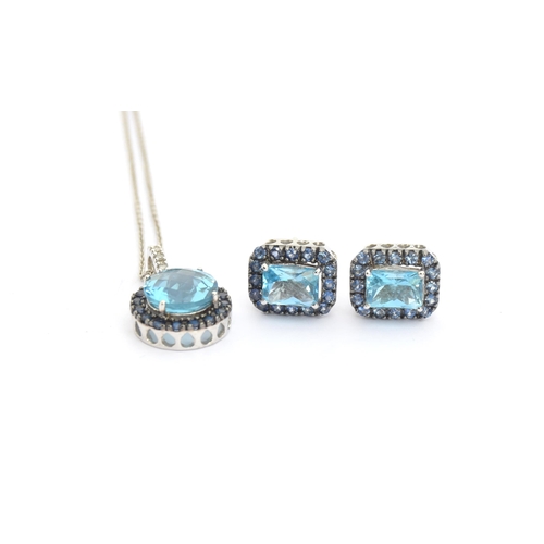 87 - A 14ct white gold pendant set with a central checkerboard cut blue topaz surrounded by sapphires, wi... 