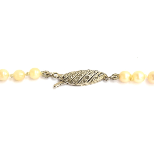 16 - An early 20th century pearl necklace fastening with a diamond set white metal clasp, the 105 pearls ... 