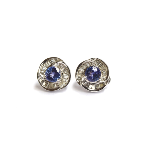 91 - A pair of heavy 18ct white gold earrings set with a central tanzanite, 6.5mm diameter, surrounded by... 