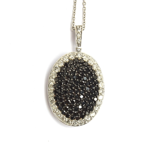 65 - A 14ct white gold pendant pave set with black and white diamonds, 2.1cm long excluding bail, on a 14... 