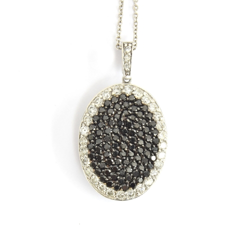 65 - A 14ct white gold pendant pave set with black and white diamonds, 2.1cm long excluding bail, on a 14... 