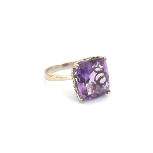 85 - A 14ct white gold and amethyst ring, the large amethyst mounted in a scrolling diamond studded pierc... 