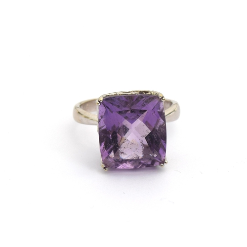 85 - A 14ct white gold and amethyst ring, the large amethyst mounted in a scrolling diamond studded pierc... 