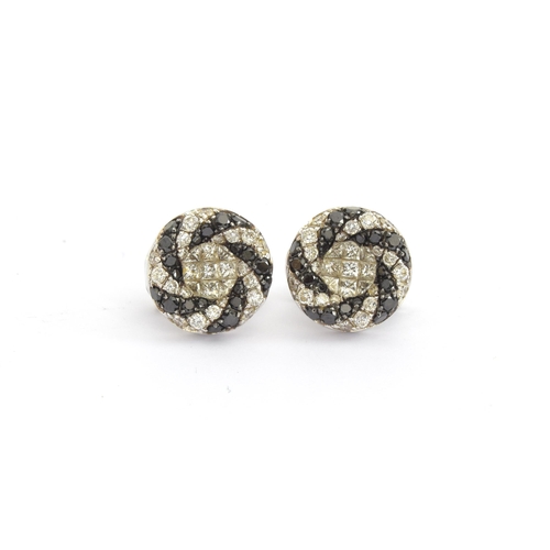 64 - A pair of 18ct white gold Oliva earrings set with black and white diamonds in a swirl design, total ... 