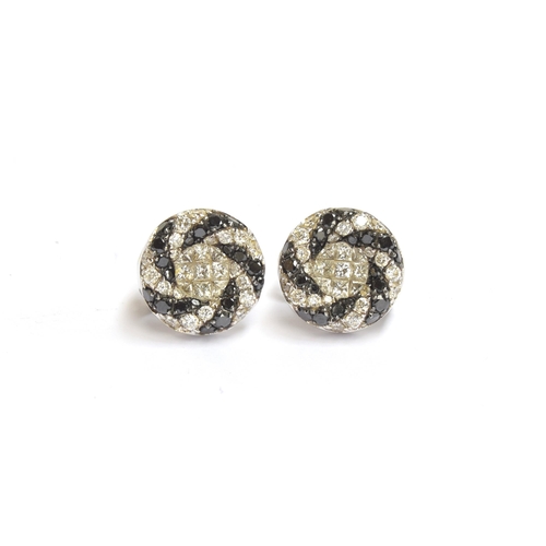 64 - A pair of 18ct white gold Oliva earrings set with black and white diamonds in a swirl design, total ... 