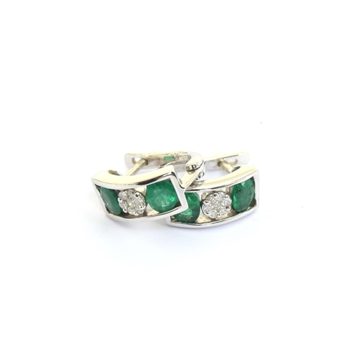 53 - A pair of 14ct white gold, emerald and diamond earrings, total carat weight of the four emeralds app... 