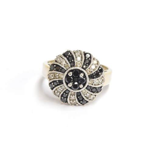 62 - A 14ct white gold ring set with white and black diamonds in swirl design, total carat weight approx.... 