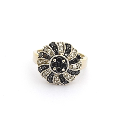 62 - A 14ct white gold ring set with white and black diamonds in swirl design, total carat weight approx.... 