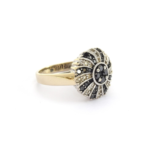 62 - A 14ct white gold ring set with white and black diamonds in swirl design, total carat weight approx.... 