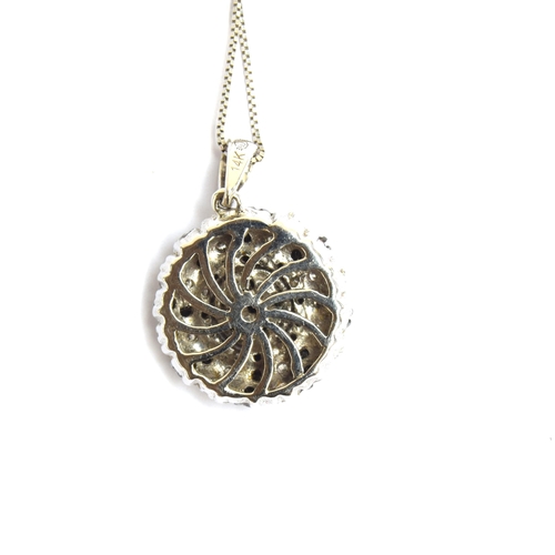 63 - A 14ct white gold pendant set with black and white diamonds in a swirl design, 15cm diameter, on a 1... 