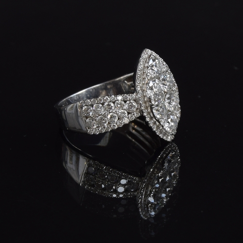 76 - A substantial 18ct white gold diamond ring of navette form, the six central large diamonds set overl... 