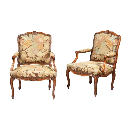 513 - A pair of beechwood fauteuil armchairs in Louis XV design, early 20th century, with needlework uphol... 