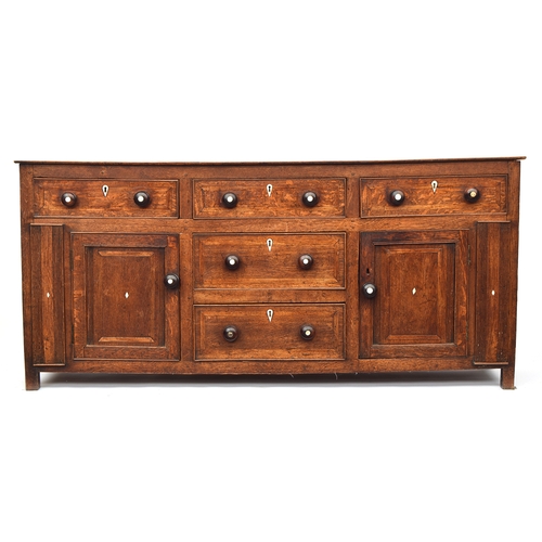 448 - A George III oak dresser base, comprising three drawers, two central drawers flanked by cupboard doo... 