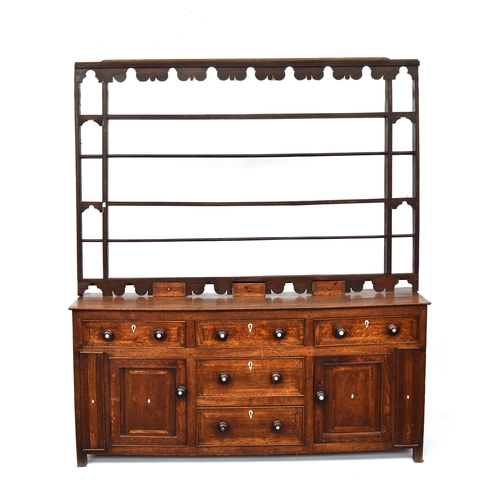 448 - A George III oak dresser base, comprising three drawers, two central drawers flanked by cupboard doo... 