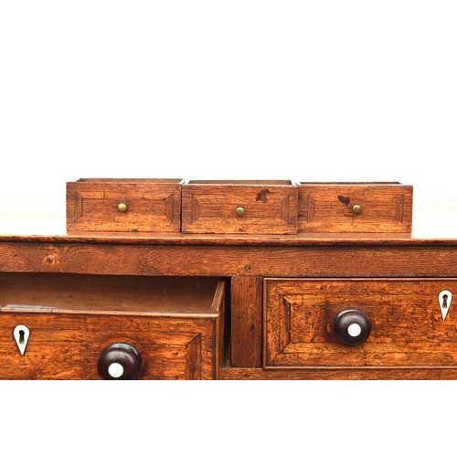 448 - A George III oak dresser base, comprising three drawers, two central drawers flanked by cupboard doo... 