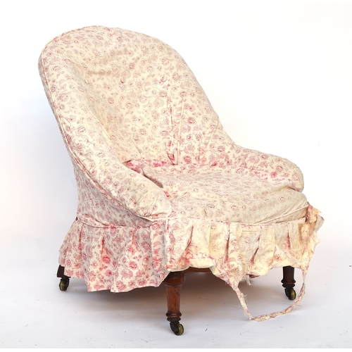 507 - A shapely Victorian button back armchair, in need of reupholstery, on turned front legs and brass ca... 