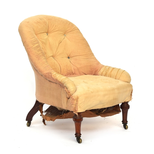 507 - A shapely Victorian button back armchair, in need of reupholstery, on turned front legs and brass ca... 