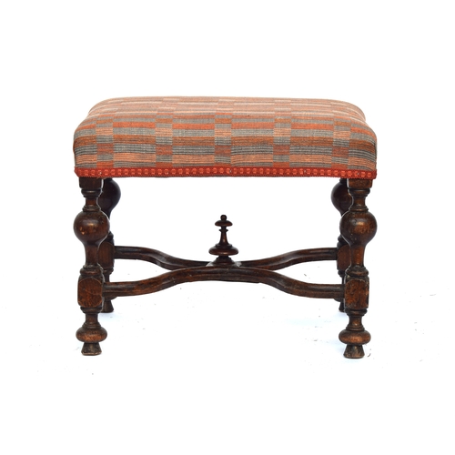 504 - A William and Mary style upholstered footstool, the block turned legs joined by a shaped X stretcher... 