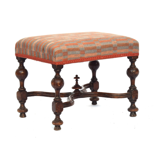 504 - A William and Mary style upholstered footstool, the block turned legs joined by a shaped X stretcher... 