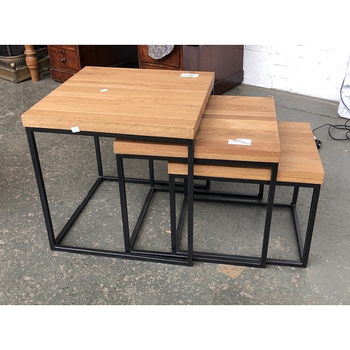 827 - A nest of three oak topped and fabricated metal occasional tables, the largest 50x50x50cm