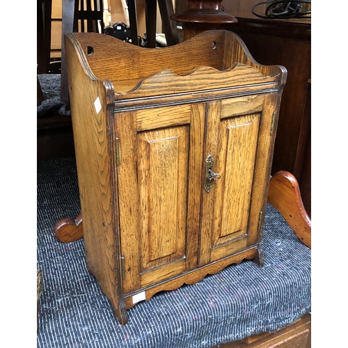 1096 - A small oak smoker's cabinet, with galleried top above two panelled doors, opening to a fitted inter... 