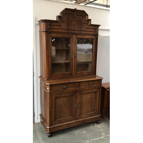 1198 - An Italian walnut library bookcase, glazed top over a base with two drawers and panelled cupboard do... 