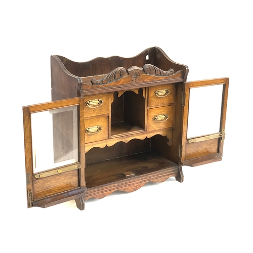 814 - A 19th century oak smokers cabinet, glazed doors  with bevelled glass, opening to a fitted interior ... 