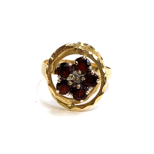 65 - A yellow metal garnet cluster ring, size O 1/2, 3.4g