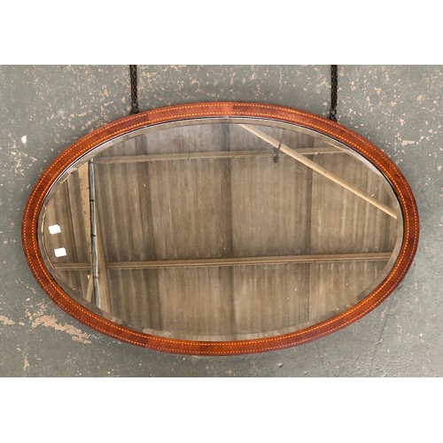 746 - An Edwardian oval wall mirror, mahogany frame with barber's pole stringing, bevelled glass, 99x62cm