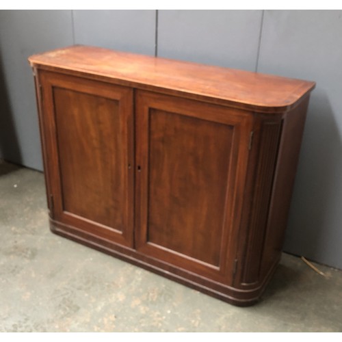 1076 - A mahogany and crossbanded cabinet, fielded panel doors opening to a single adjustable shelf, flanke... 