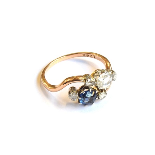 54A - An early 20th century 18ct gold 'Toi et Moi' diamond and sapphire crossover ring, the large rose cut... 