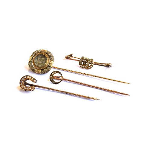 34A - A gold mounted Victorian hair work stick pin, the glazed compartment having plaited hair, surrounded... 